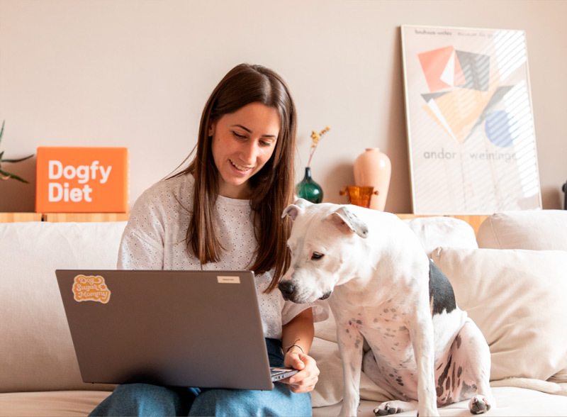 Une femme et son chien qui regardent le site internet dogfydiet